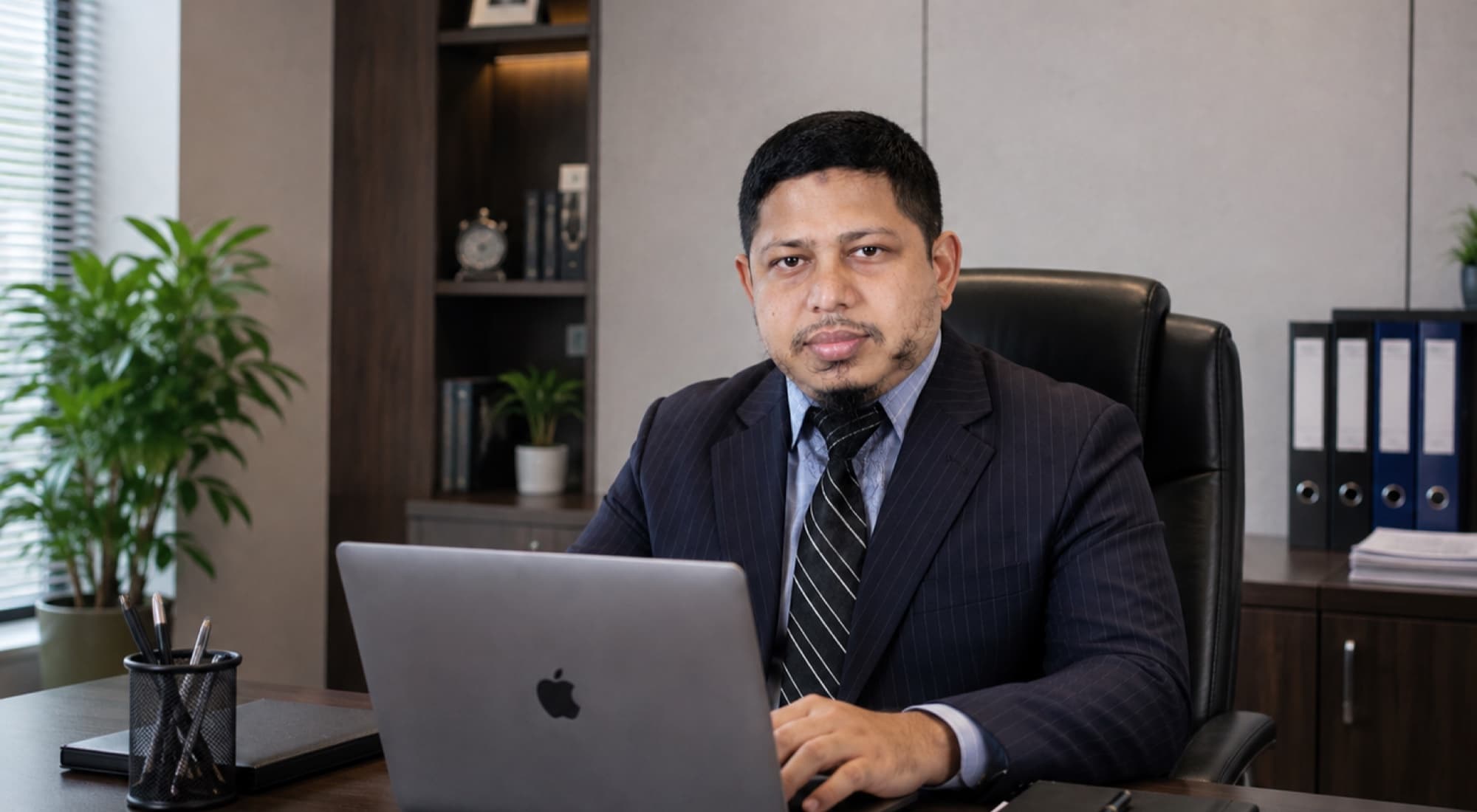 A consultant at his desk in a Dhaka office